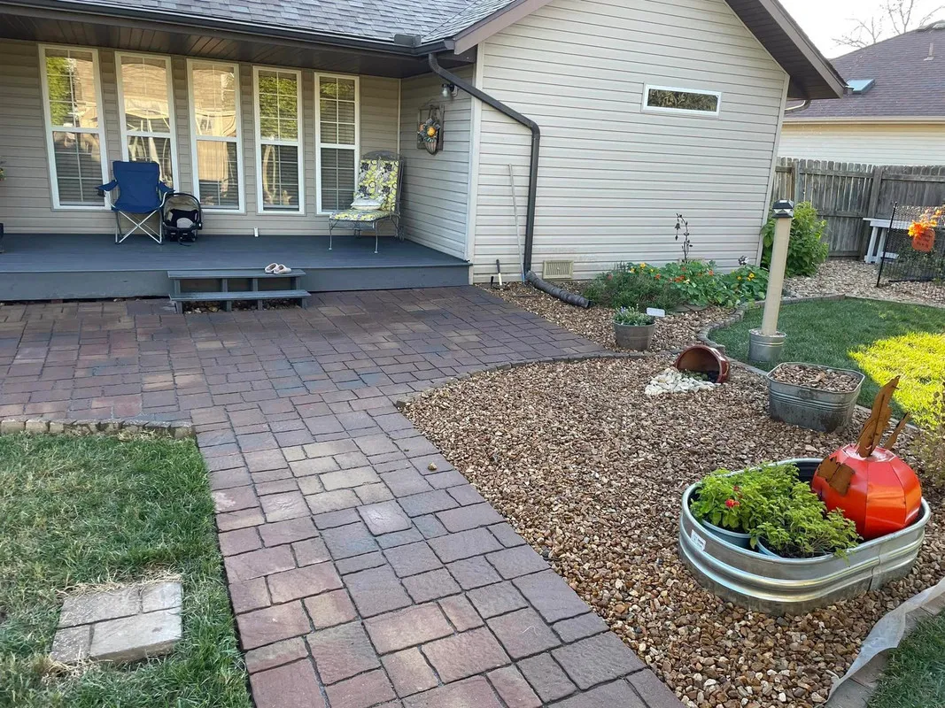 A paver patio with stone borders in a backyard setting